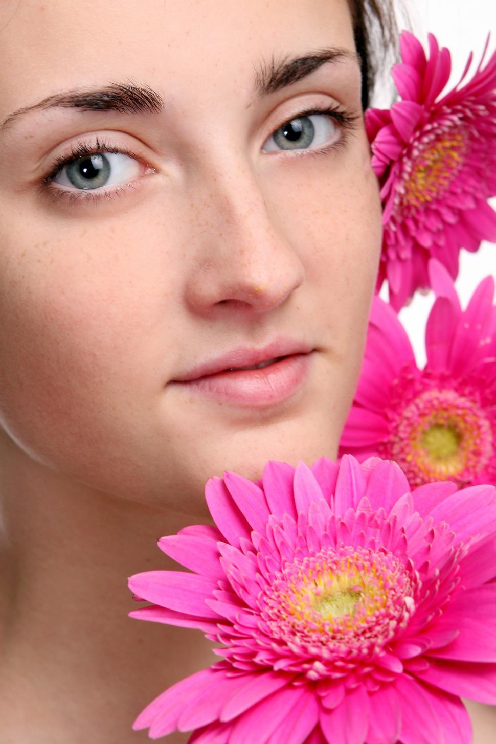 Free Image of Young woman surrounded by pink flowers 