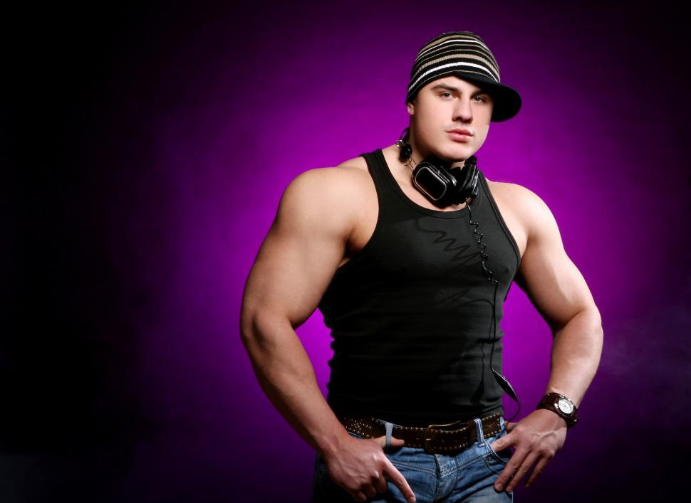 Free Image of Muscular guy in hat, standing in the light 