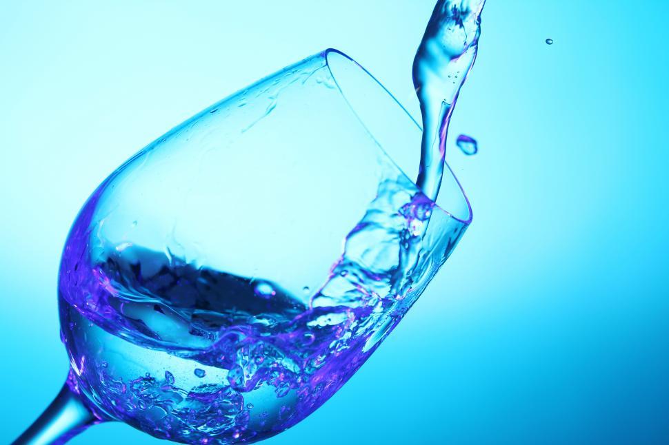 Free Image of Pouring into a wine glass, colored background 