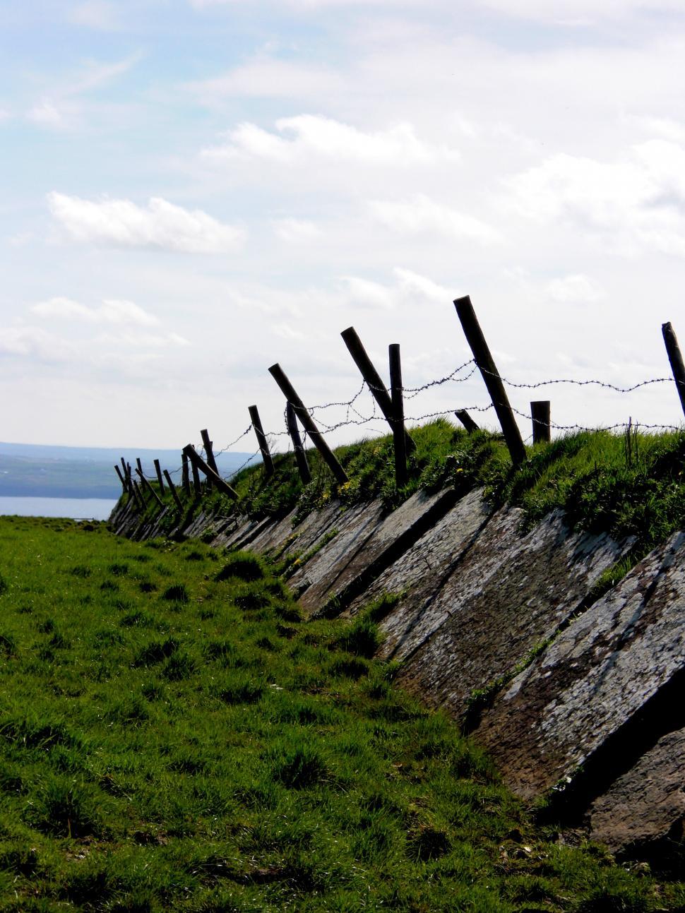 Free Image of Barbed Wire Fence Along Grass Field 