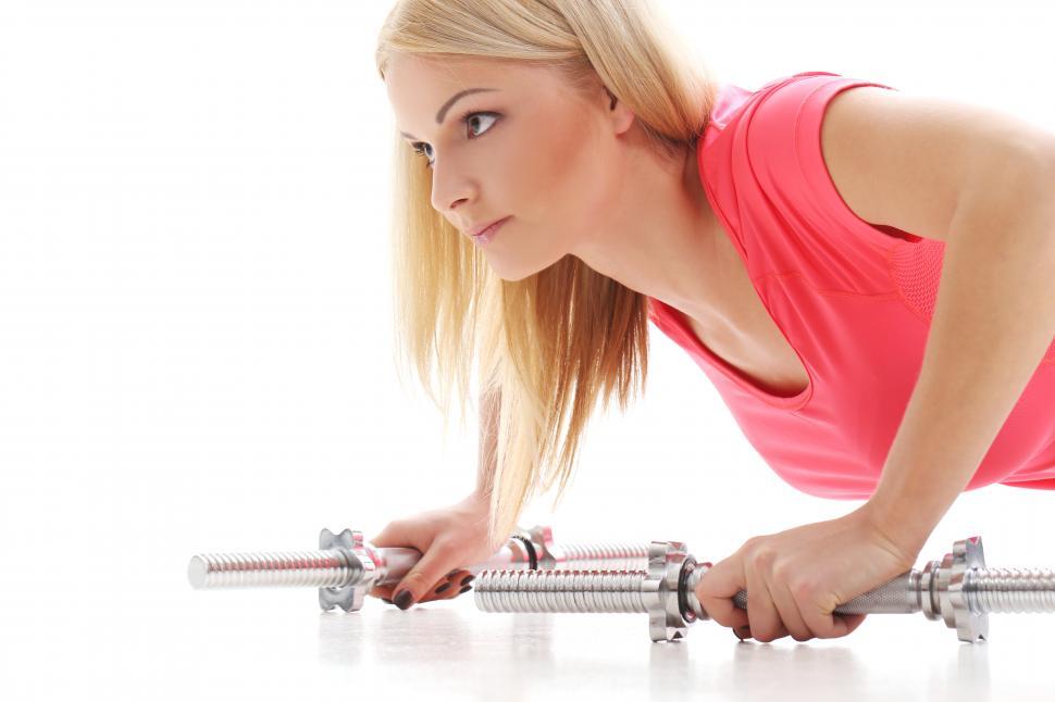 Free Image of Woman doing pushups off weight bars 