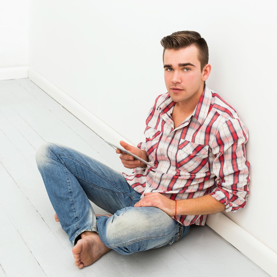 Free Image of Guy hanging out on the floor with mobile device 