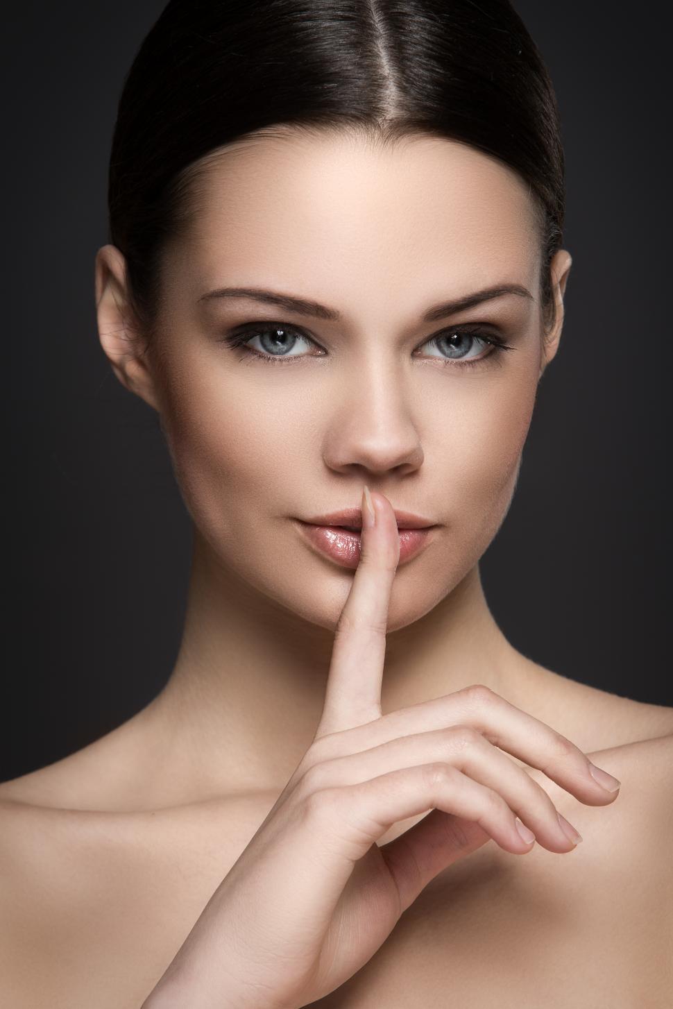 Free Image of Beautiful brunette woman with finger to her lips. Shhh. 