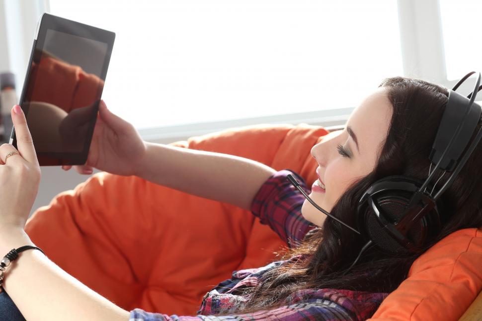 Free Image of Lifestyle. Seated girl with tablet computer and headset 
