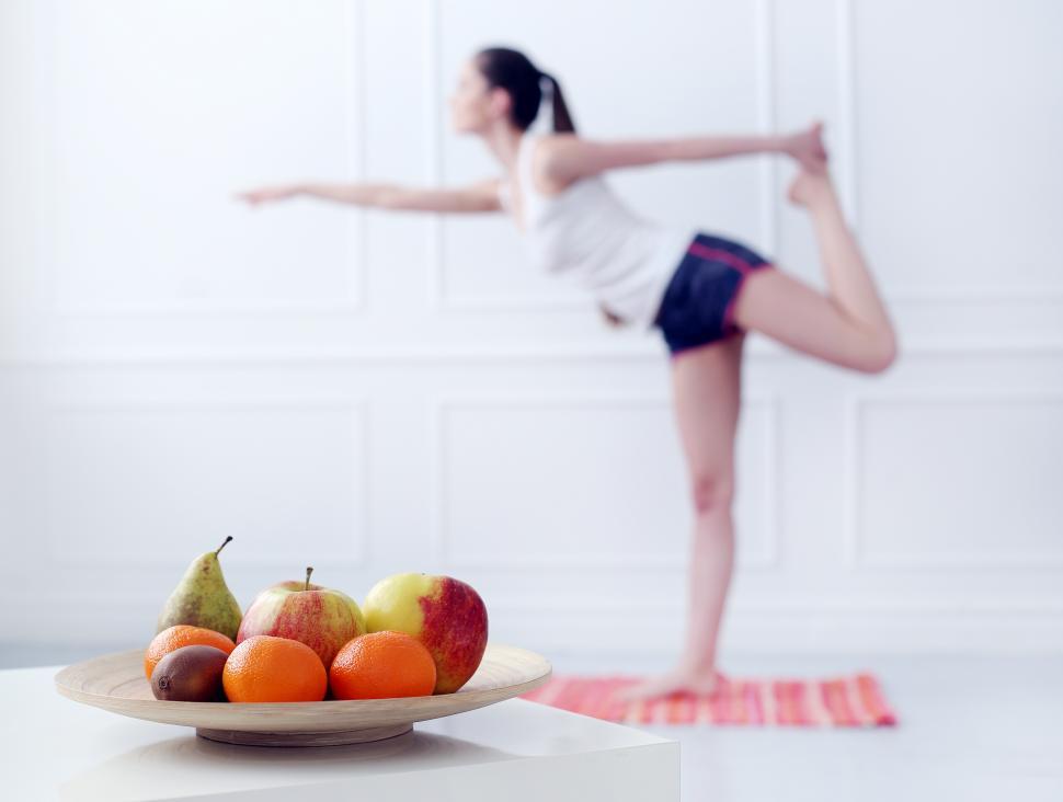 Free Image of Lifestyle. Plate of fruit and woman in standing yoga pose 