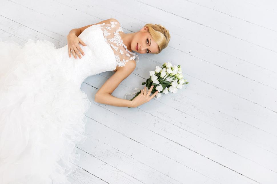 Free Image of Wedding. Beautiful bride laying on white floorboards 