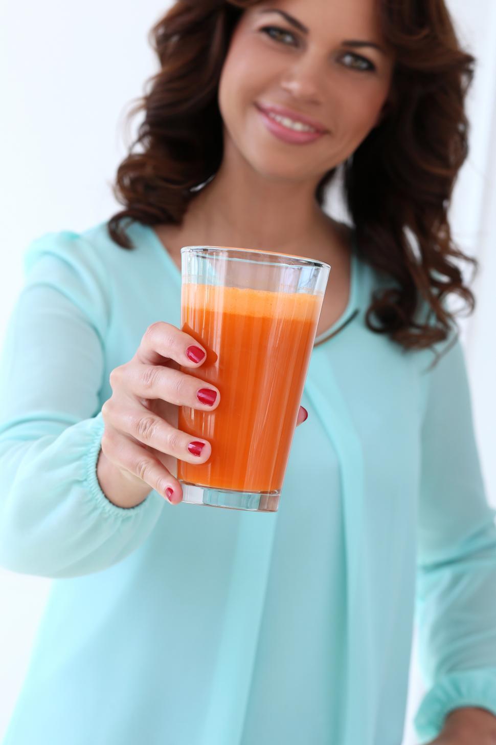 Free Image of Woman offering glass of juice 
