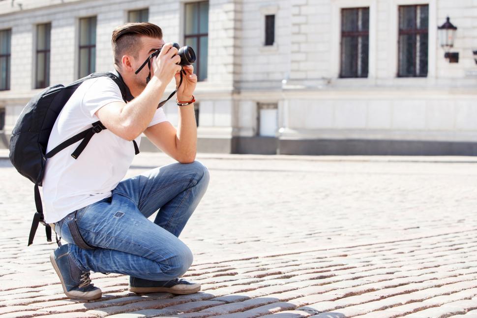 Free Image of Crouching to take a photo in the street 