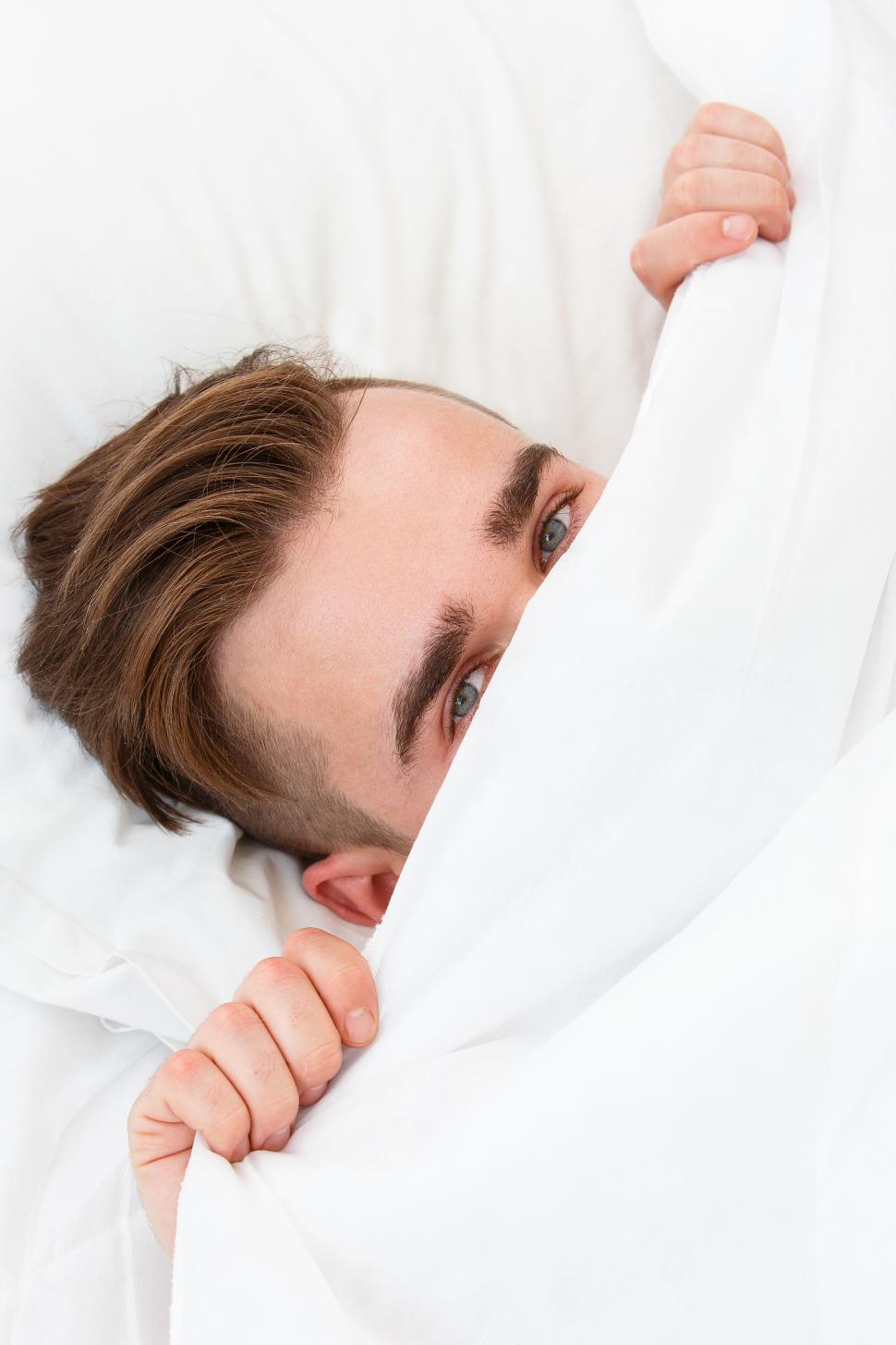 Free Image of Young man hiding in the bed. 