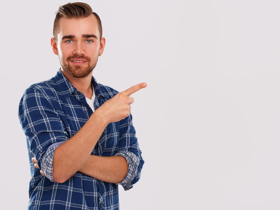 Free Image of Emotions. Young man in blue shirt, pointing at copyspace 