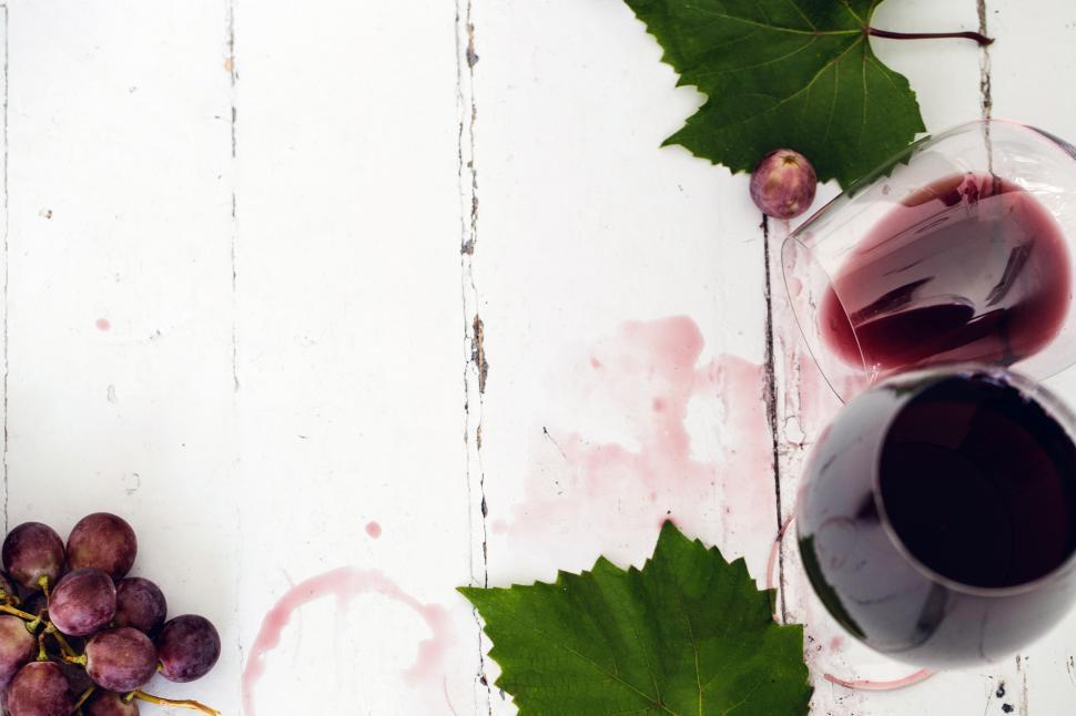 Free Image of Red wine spilled on white wooden table 