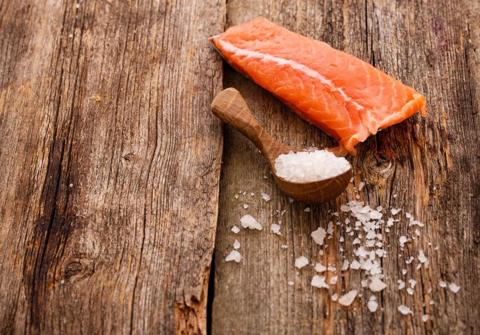Free Image of Slice of raw salmon and rock salt on wooden surface 