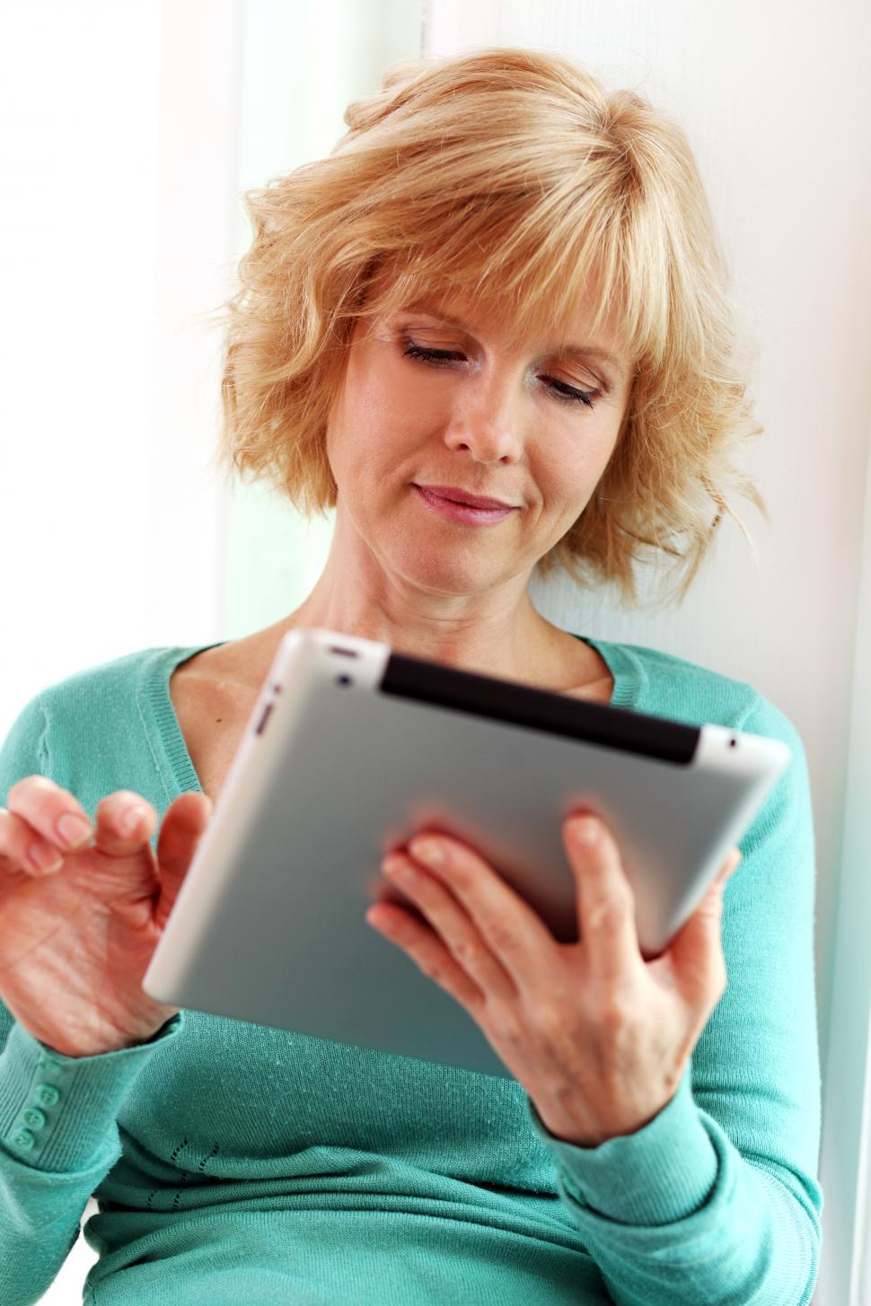 Free Image of Middle aged woman relaxing with tablet computer 