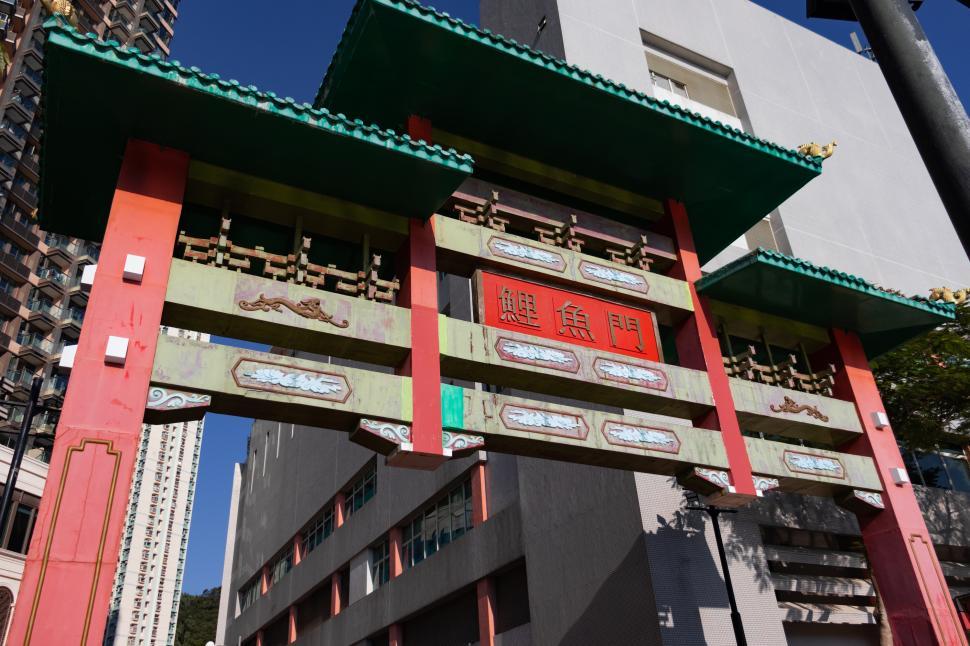 Free Image of Tall Red and Green Building Next to Another Tall Building 