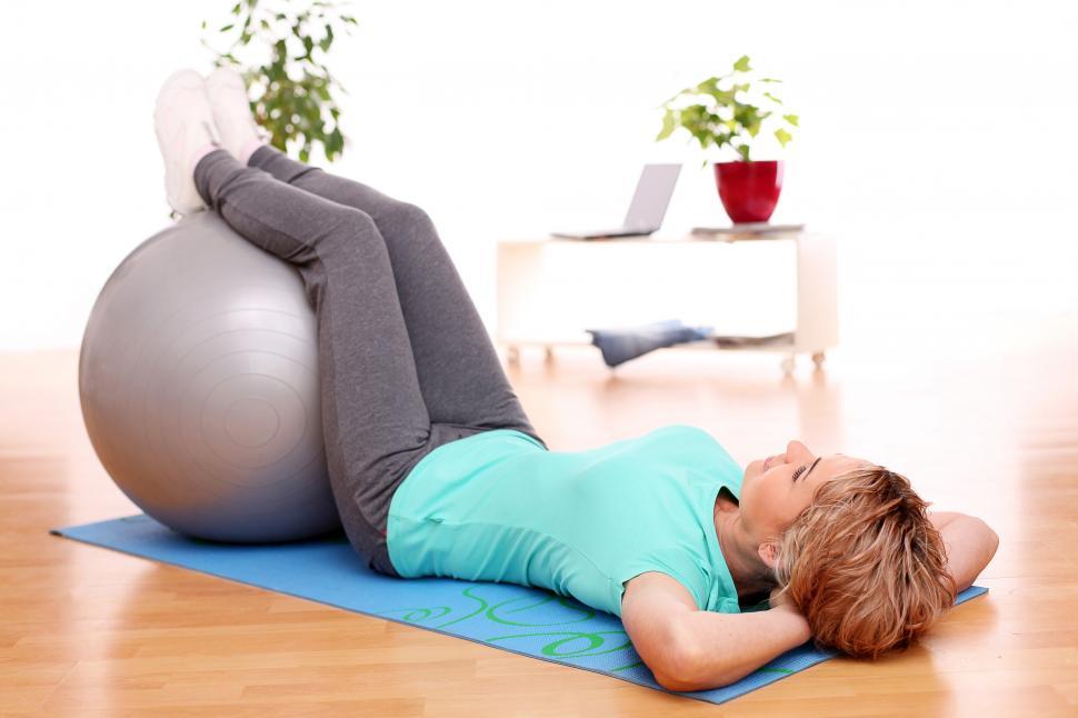 Free Image of Woman working out with feet up on exercise ball 