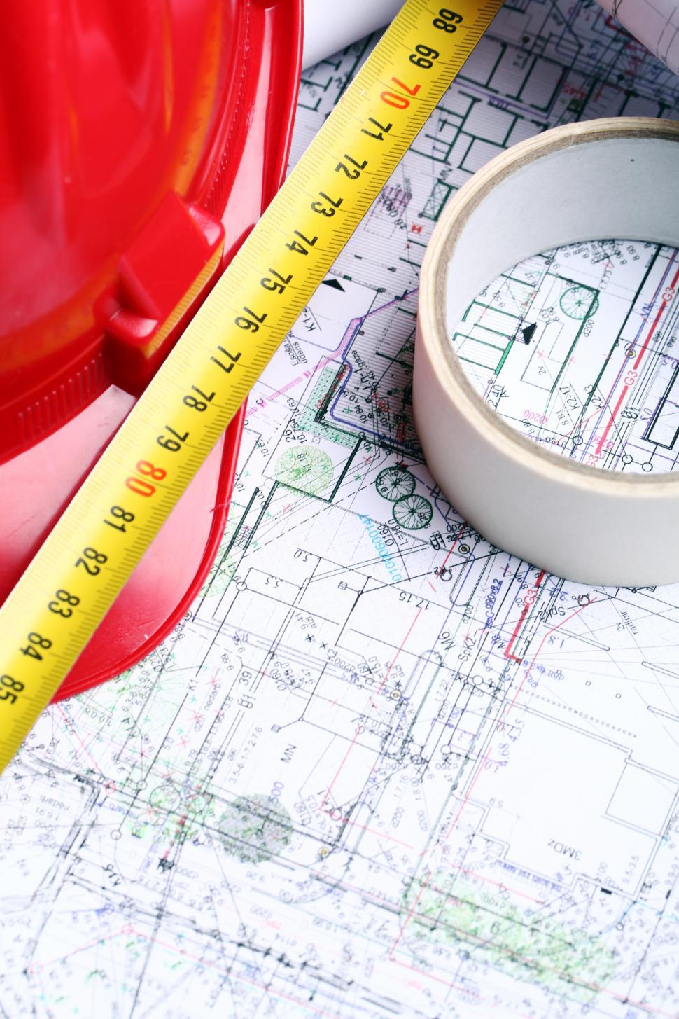 Free Image of Construction blueprints, tape and hard hat 