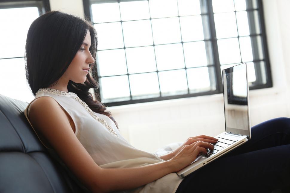 Free Image of Woman sitting, working on a laptop computer 