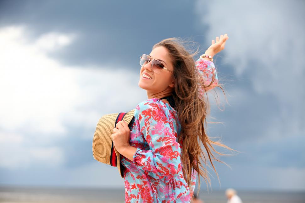 Free Image of Young woman is happy to be out on the beach 