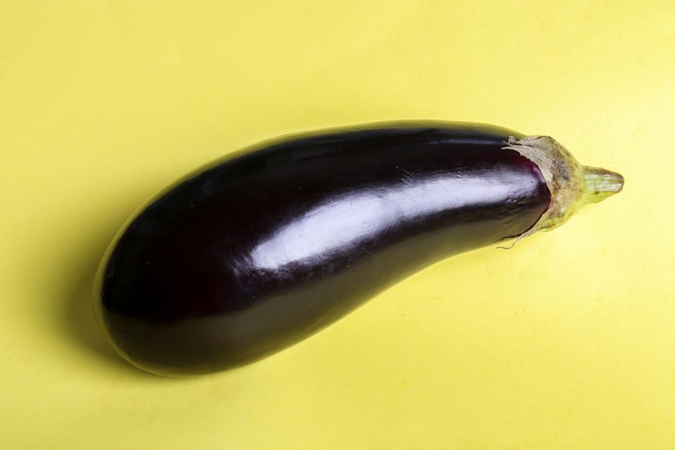 Free Image of Whole Eggplant on Yellow Background 