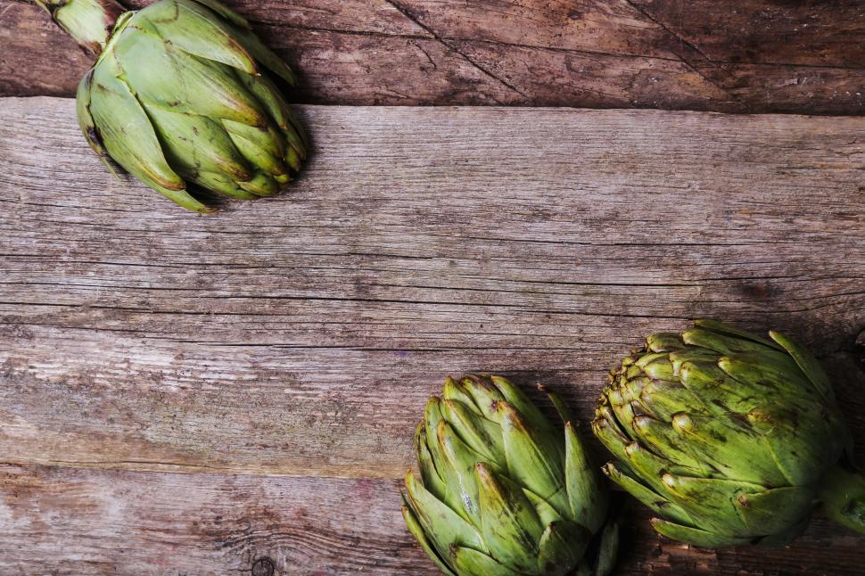 Free Image of Artichokes on textured wooden background. 