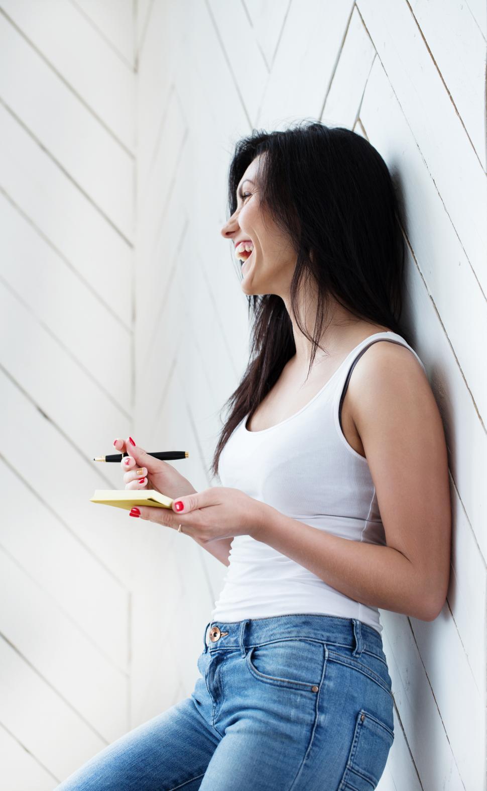 Free Image of Laughing woman, holding a note pad 