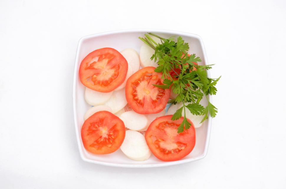 Free Image of the red tomato with radish sliced and green coriander isolated on white background. 