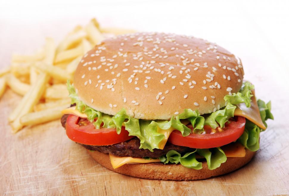 Free Image of Big burger with sesame seed bun and chips 