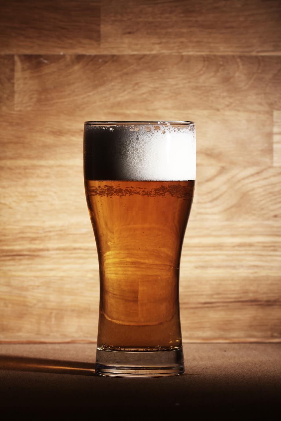 Free Image of One glass of beer over wooden background 