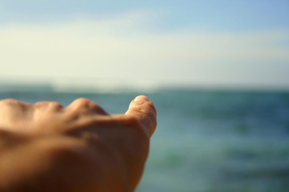 Free Image of Pointing finger and ocean 