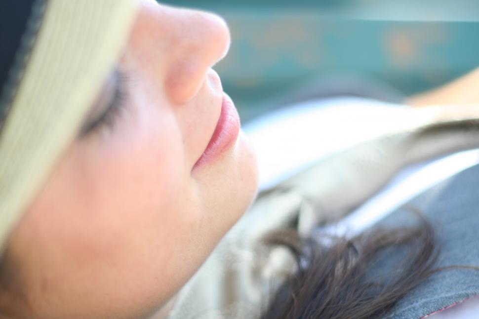 Free Image of Woman sleeping with beach hat 