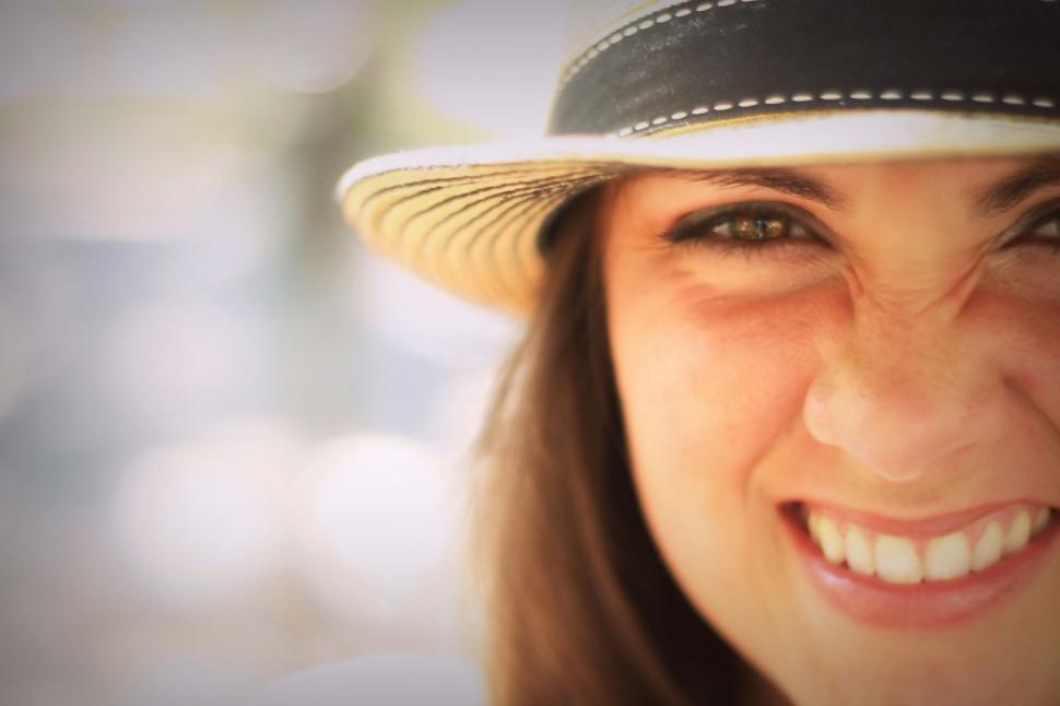 Free Image of Close up of woman face with toothy smile and hat 