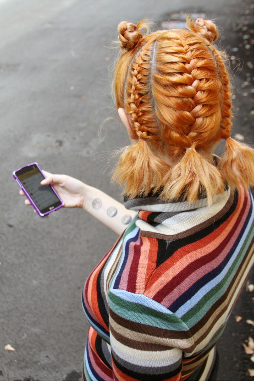Free Image of Back side view of stylish blonde woman with cellphone 