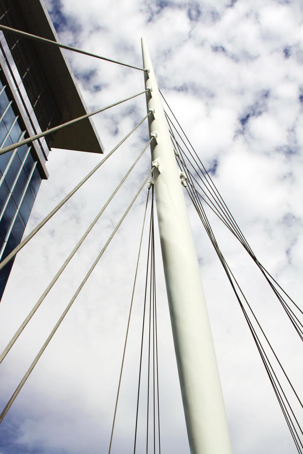 Free Image of Bridge cables and building with white clouds 