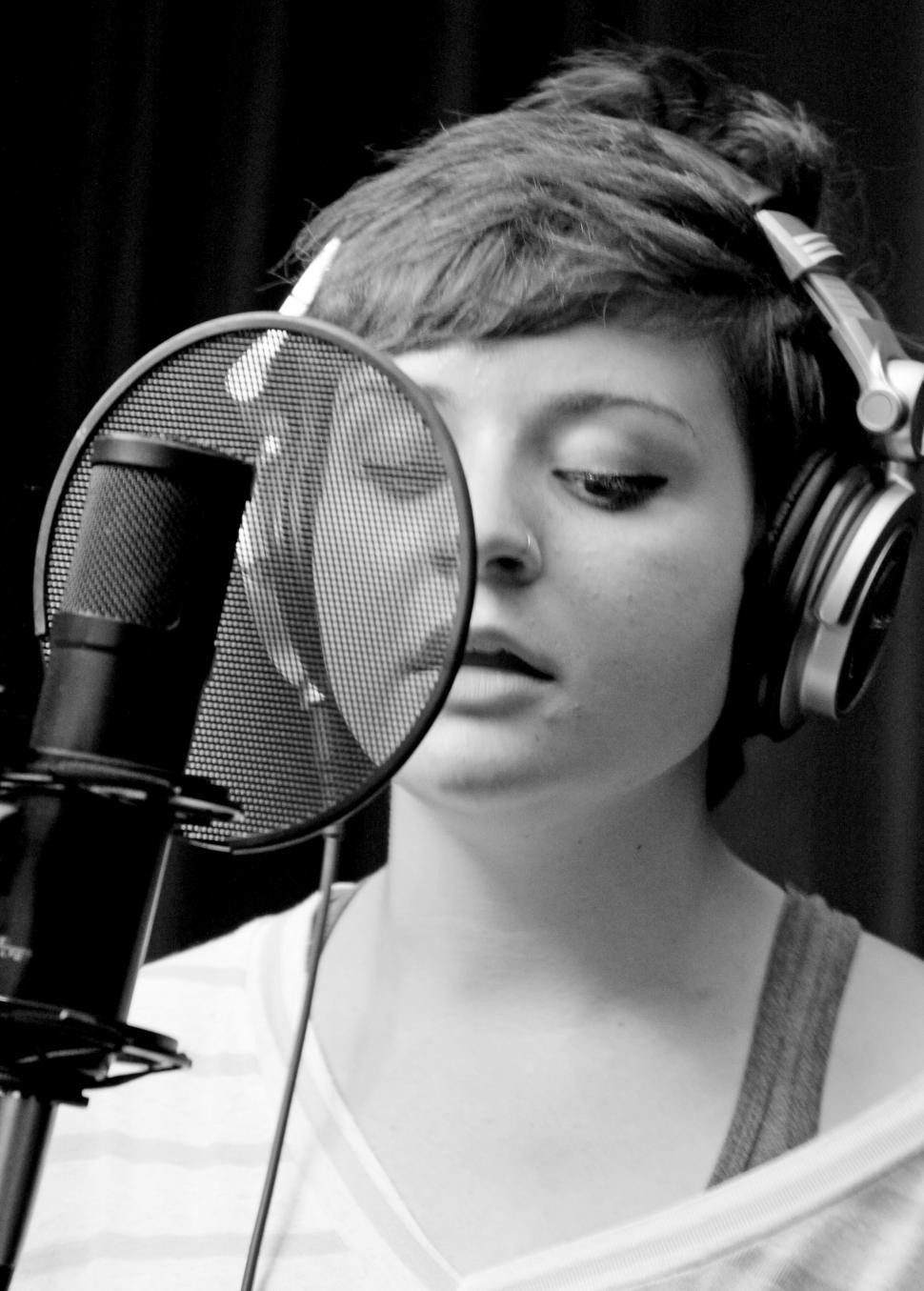 Free Image of Woman singing with mic in recording studio 