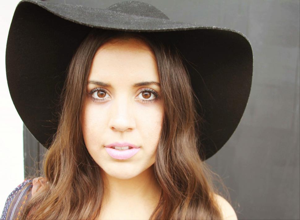 Free Image of Female fashion model with long brunette hair and hat 