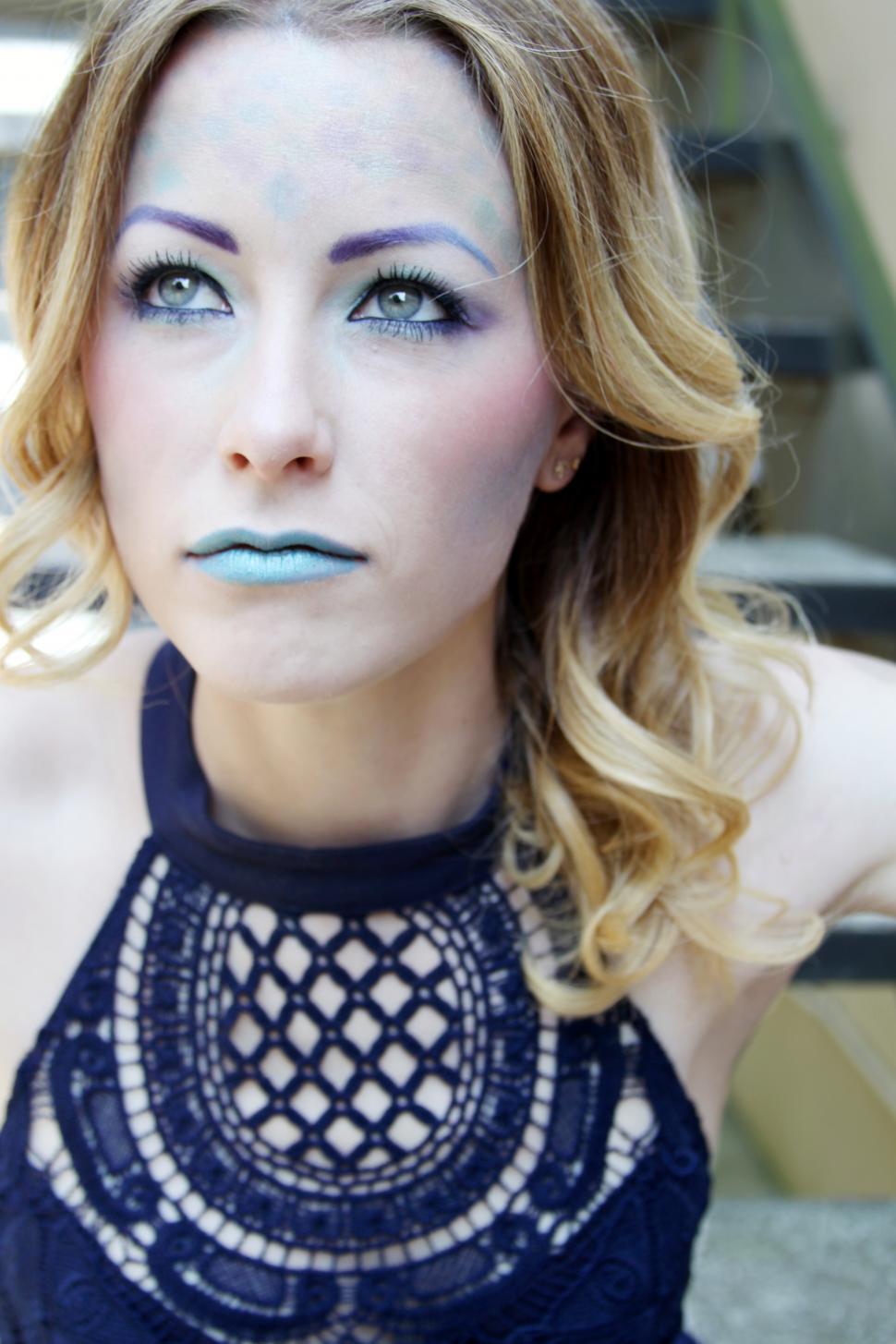 Free Image of Female fashion model in blue halter neck top with makeup on face 