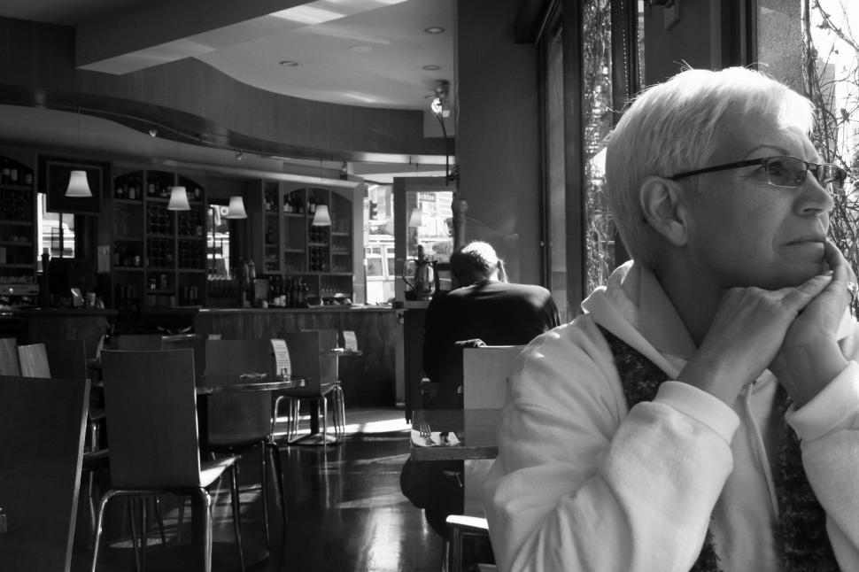 Free Image of Old woman sitting in cafe - b&w 