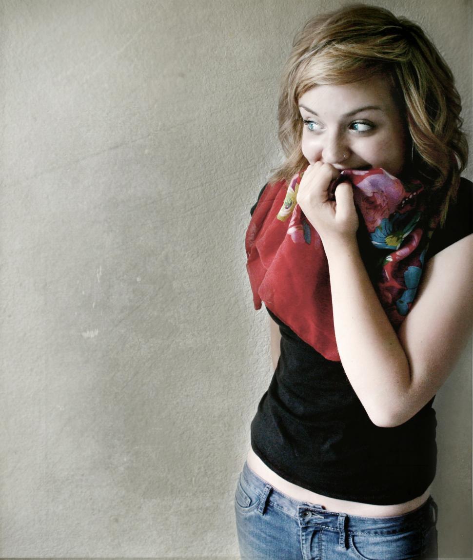 Free Image of Smiling teenage girl covering face with scarf 