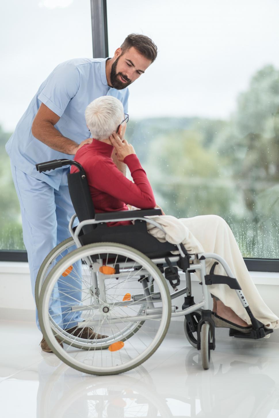 Free Image of Healthcare worker with old-aged woman in wheelchair - taking car 