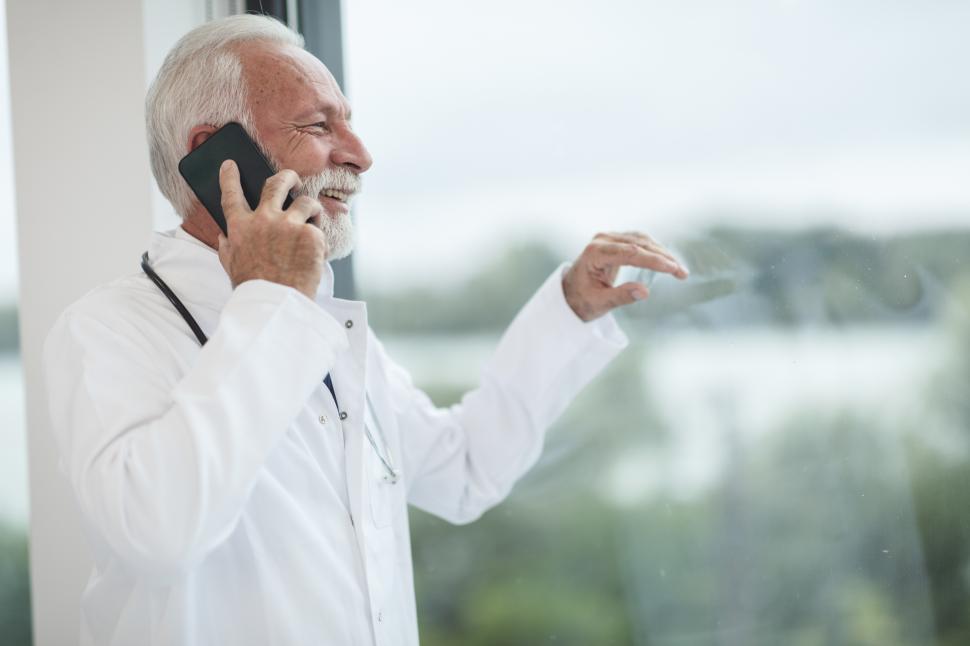 Free Image of Smiling male doctor with mobile phone 