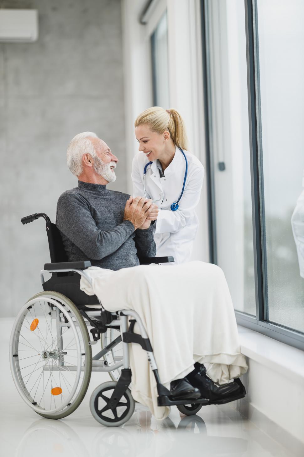 Free Image of Female doctor with old-aged man in wheelchair 