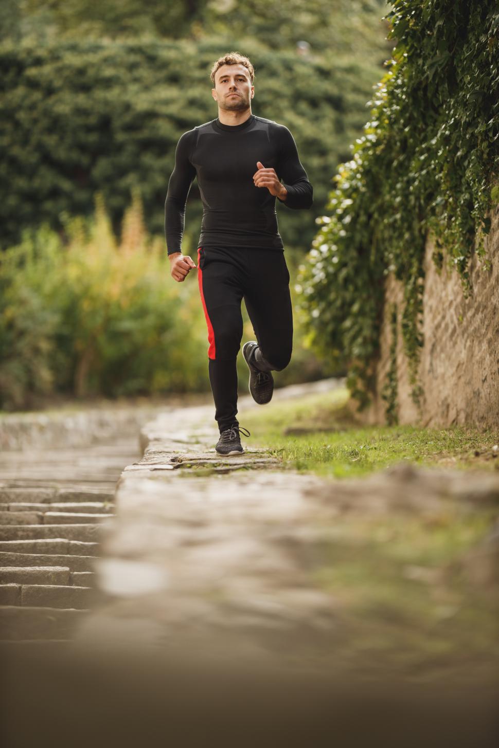 Free Image of Male athlete running in the park - looking at camera 