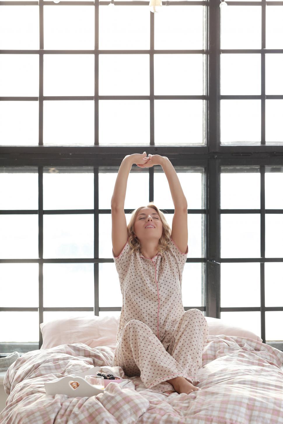 Free Image of Woman stretching in bed 