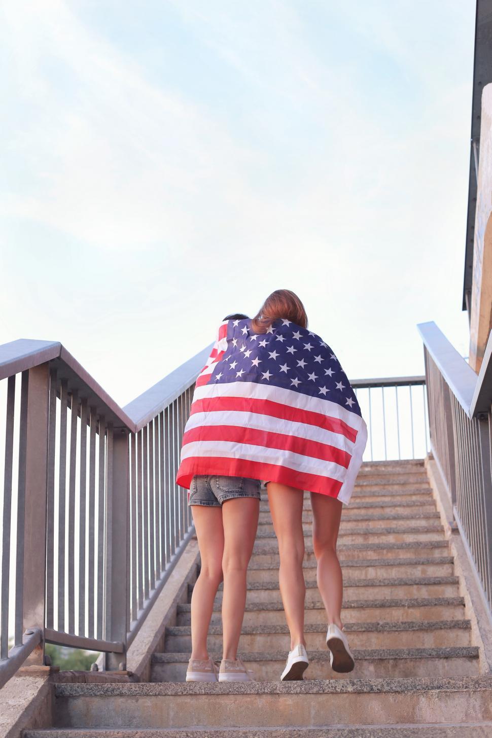 Free Image of Two women wrapped in an American flag 