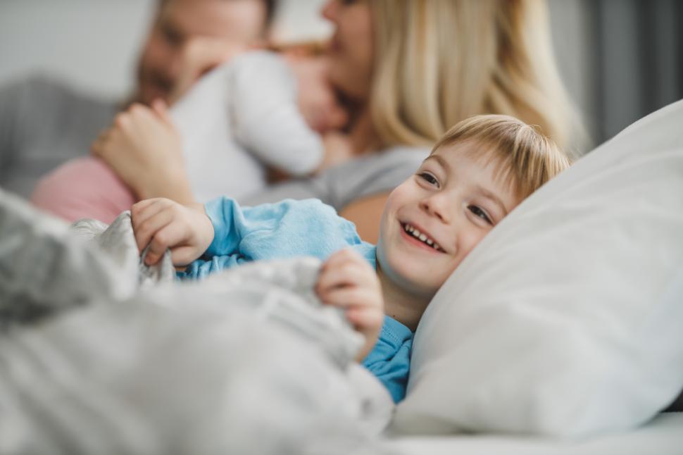 Free Image of Smiling little boy with family in bed 