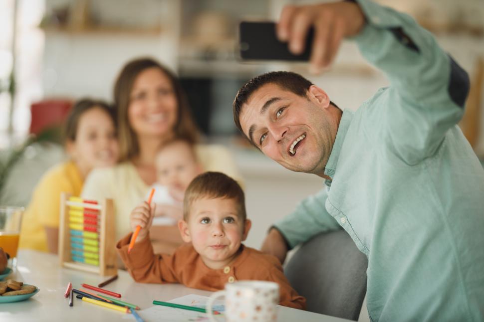 Free Image of Cheerful family with children taking selfie together on phone 