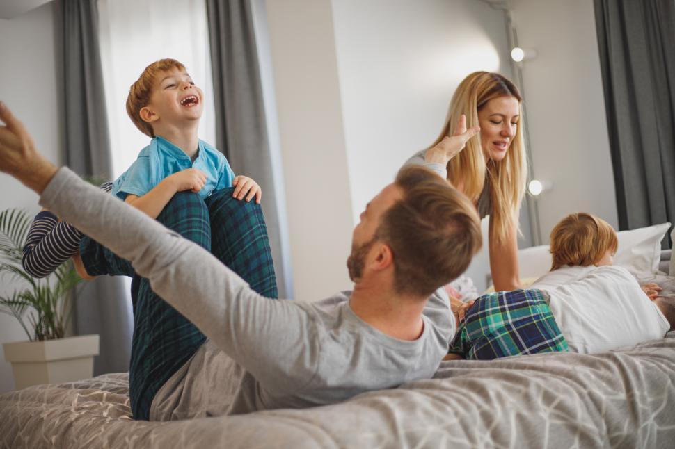 Free Image of Cheerful family with children on bed 