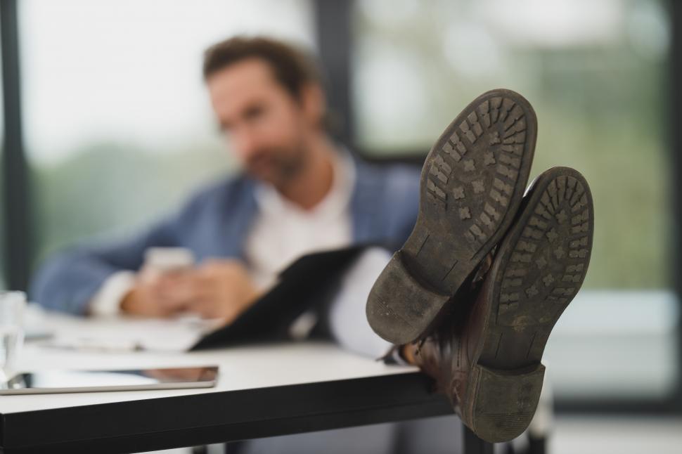 Free Image of Man sitting in office with feet on desk 