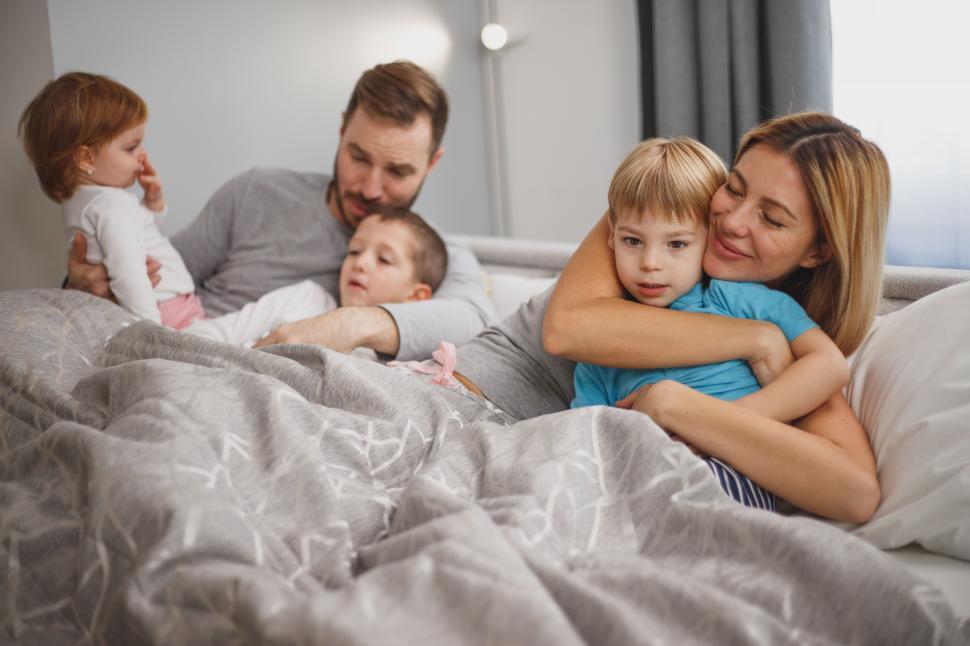 Free Image of Happy Caucasian family with kids, cozy on the bed 