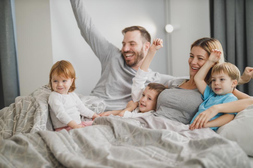 Download Free Stock Photo of Happy Caucasian family with three kids in bed 